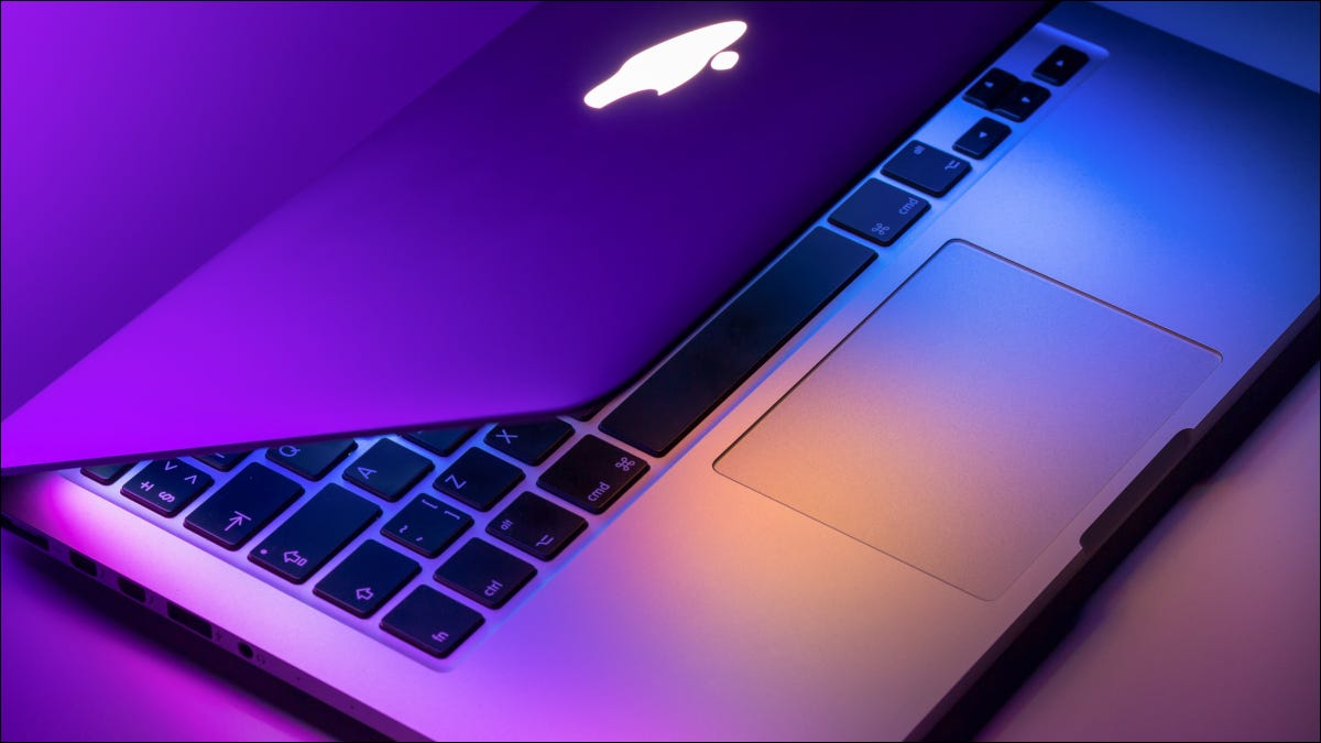 MacBook Pro parcialmente abierto con luces violetas y azules