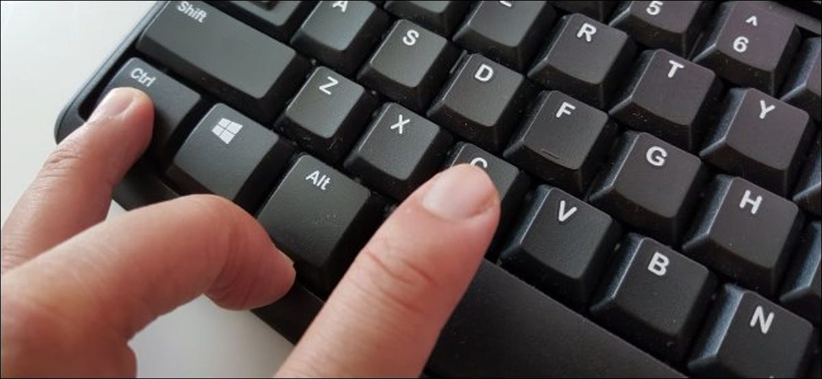 Dedos presionando Ctrl + C para copiar texto en un teclado de PC.