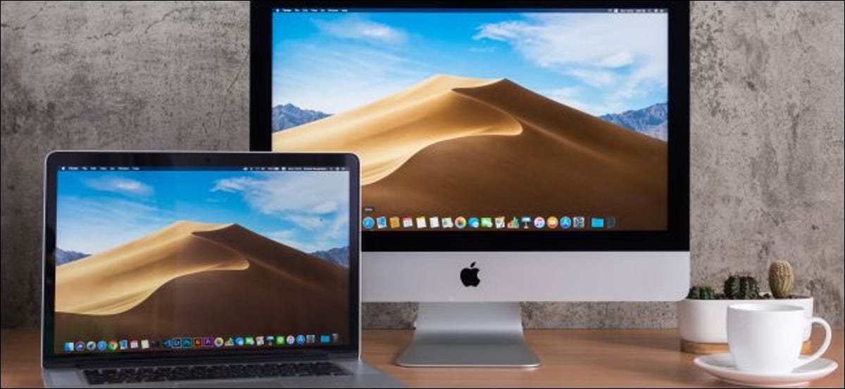 Um iMac e MacBook em uma mesa.