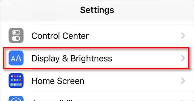En la configuración del iPhone, toca "Pantalla y brillo"