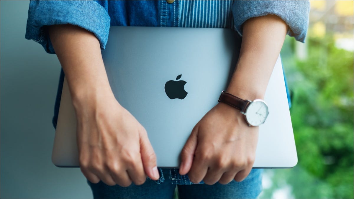 Una mujer sosteniendo un Apple MacBook Pro.