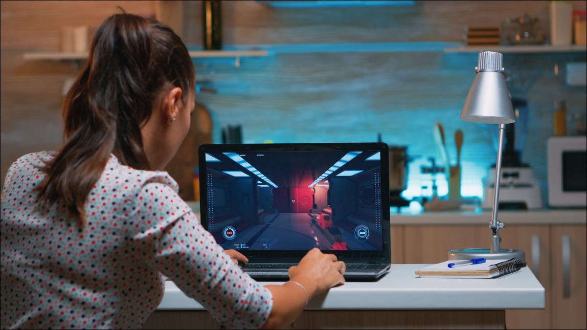 Mujer joven, juego, en, un, computadora portátil